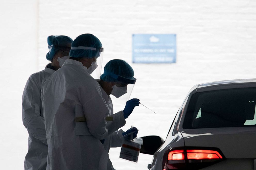 PHOTO: A healthcare worker takes a test swab of an individual at a drive-thru testing facility at George Washington University in Washington, D.C. on April 23, 2020 amid the Coronavirus pandemic.