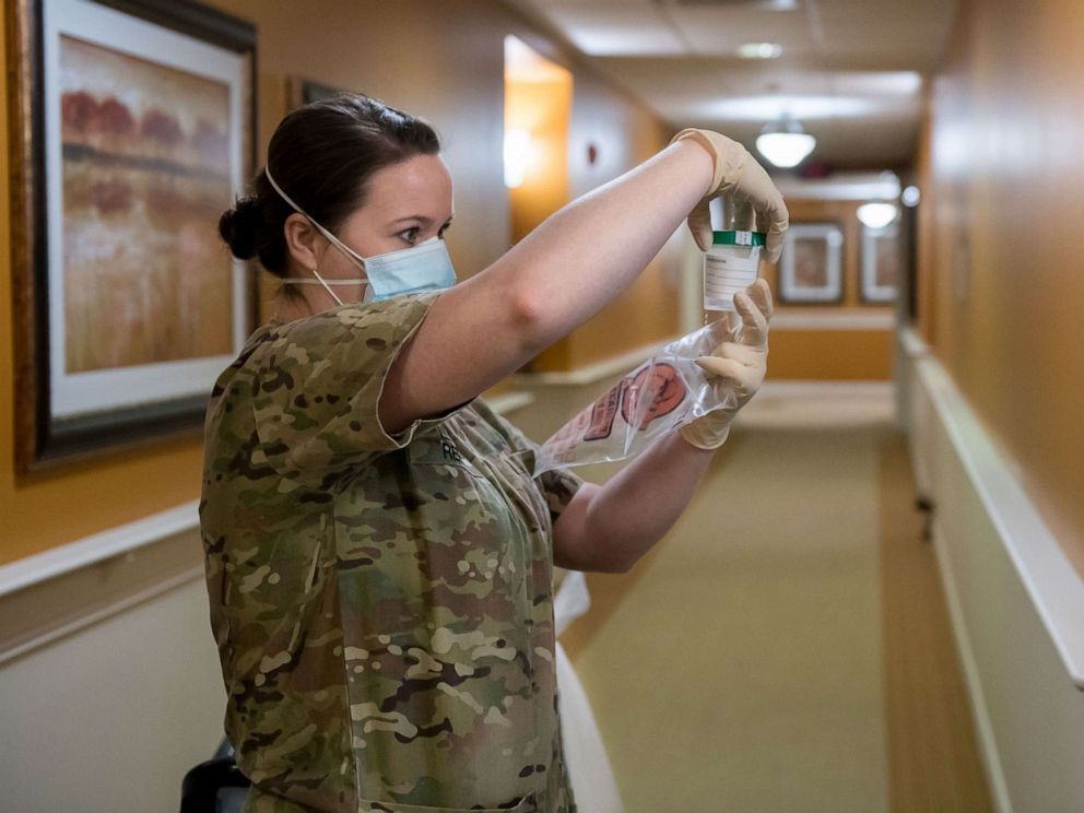 PHOTO: Staff Sgt. Rachelle Reed verifies information on a saliva sample from a resident at a long term healthcare facility in Tulsa, May 5, 2020.