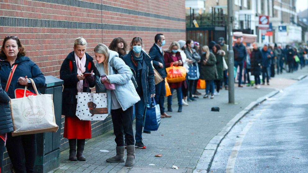 PHOTO: People queue outside the Waitrose and Partners supermarket, amid the coronavirus disease outbreak in London, Britain, Dec. 22, 2020.