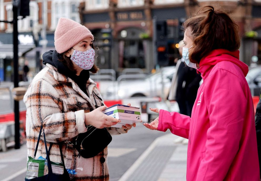 PHOTO: Volunteers hand out boxes of Covid-19 rapid antigen Lateral Flow Tests in London, Jan. 3, 2022.