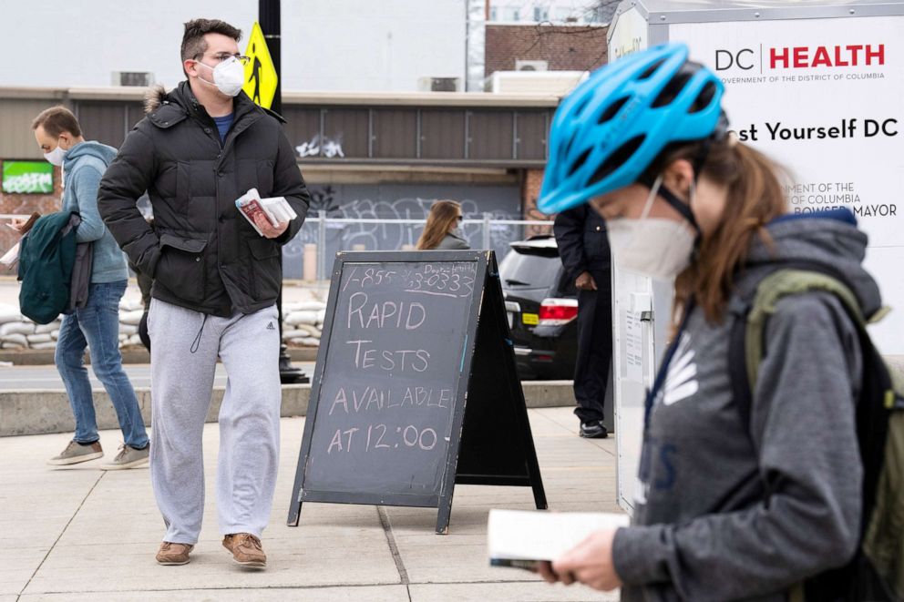 PHOTO: People pick up COVID-19 rapid antigen test kits at the Watha T. Daniel-Shaw Neighborhood Library in Washington, Dec. 29, 2021.