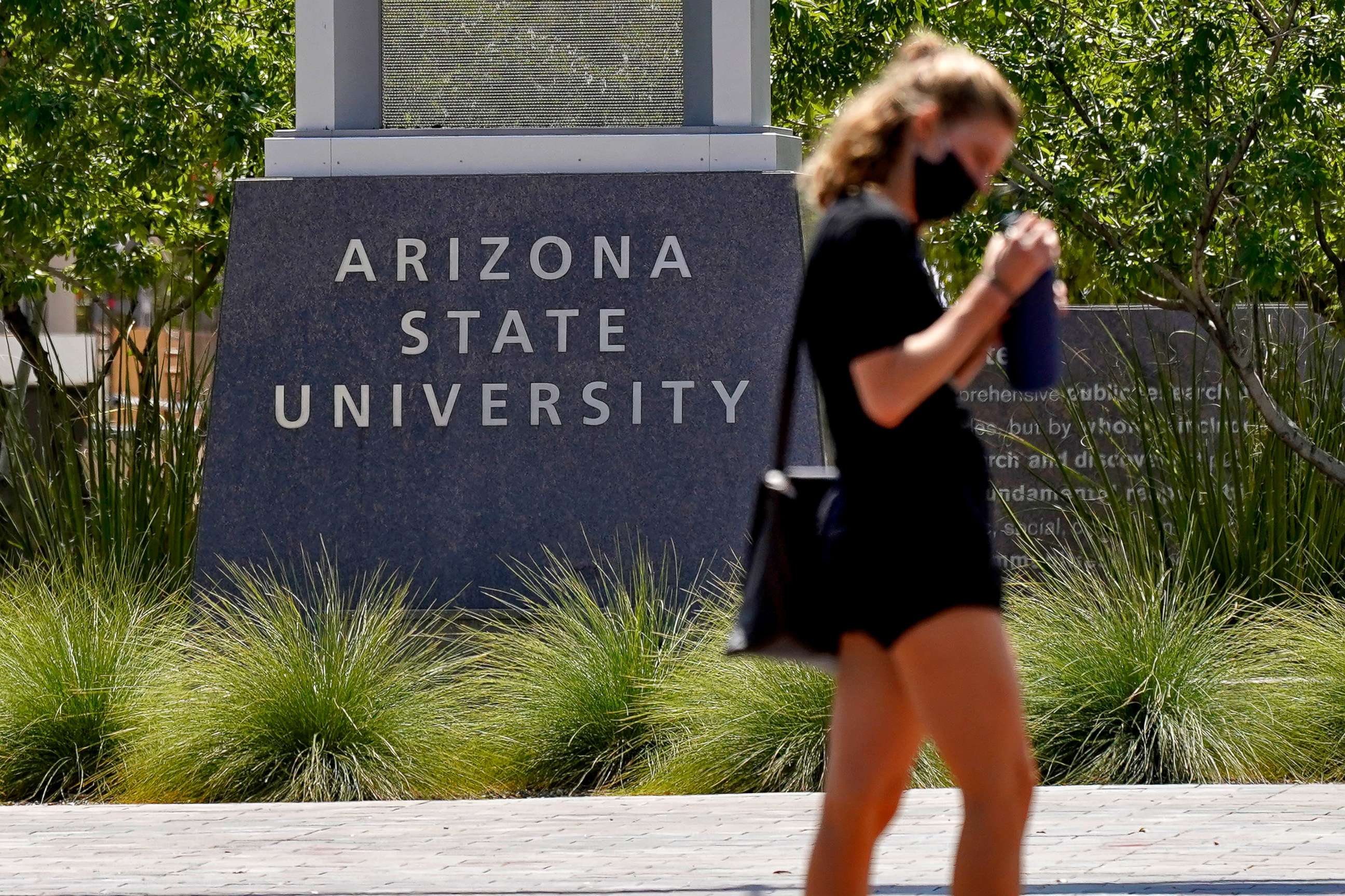 PHOTO: A pedestrian crosses a typically busy intersection on the campus of Arizona State University on Sept. 1, 2020, in Tempe, Ariz.