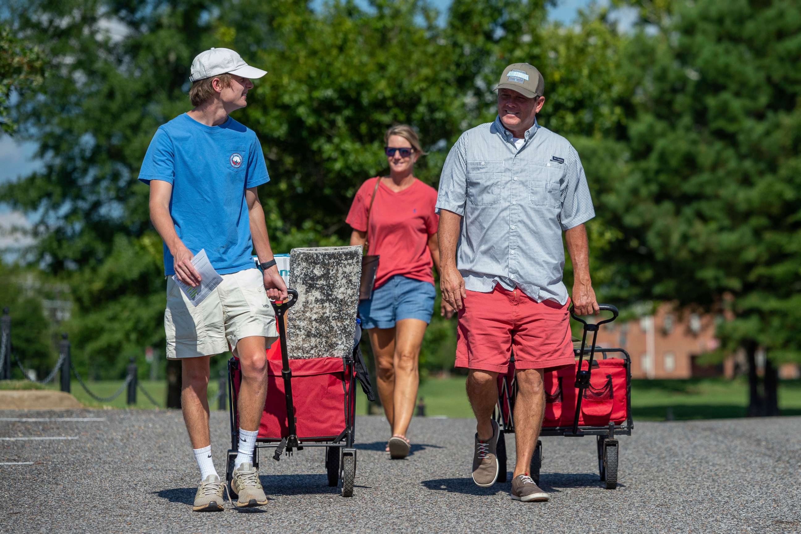 PHOTO: Baylor Garland, left, arrives to move in for his freshman year, assisted by his father Alan, right and mother, Teena, after they traveled from Eaton, Ga., at the University of Alabama campus on Aug. 15, 2020, in Tuscaloosa, Ala.