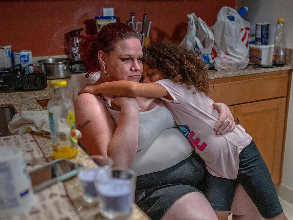 PHOTO: Kristi Phillips, 47, takes a break with daughter Shyann Slain, 7, while cleaning her kitchenette inside the Residence Inn by Marriott where she has been living with her family in Sacramento, Calif., May 28, 2021.