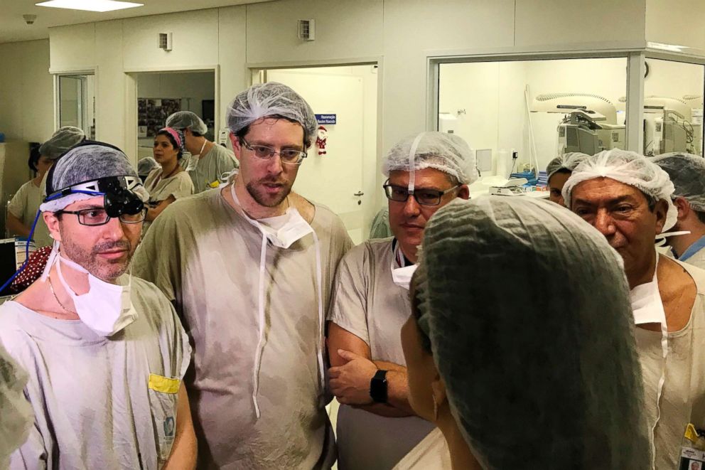 PHOTO: Dr. Wellington Andraus, left with magnifying glasses, and Dr. Dani Ejzenberg, second left, confer with colleagues at the Hospital das Clinicas of the University of Sao Paulo School of Medicine.