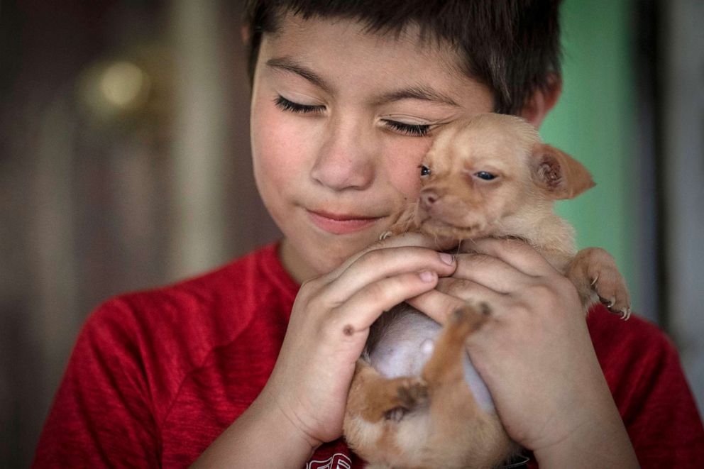 PHOTO: Eight-year-old Jeremiah Lennon hugs his puppy named "Peanut" at his home on, May 28, 2022, in Uvalde, Texas.