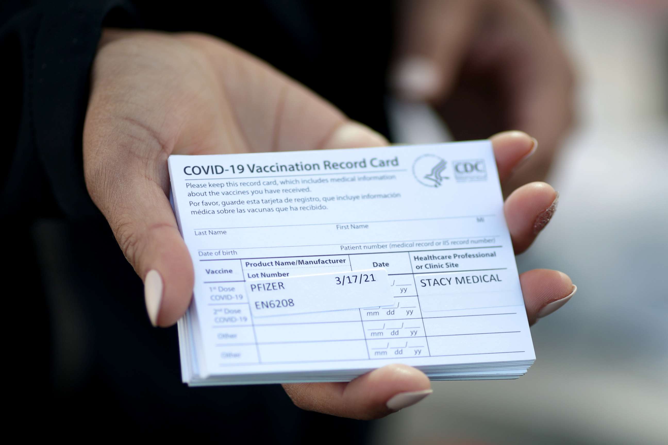 PHOTO: A medical worker holds Pfizer coronavirus vaccination cards at a mobile vaccination drive for essential food processing workers at Rose & Shore, Inc., in Vernon, Los Angeles, California, U.S., March 17, 2021. 