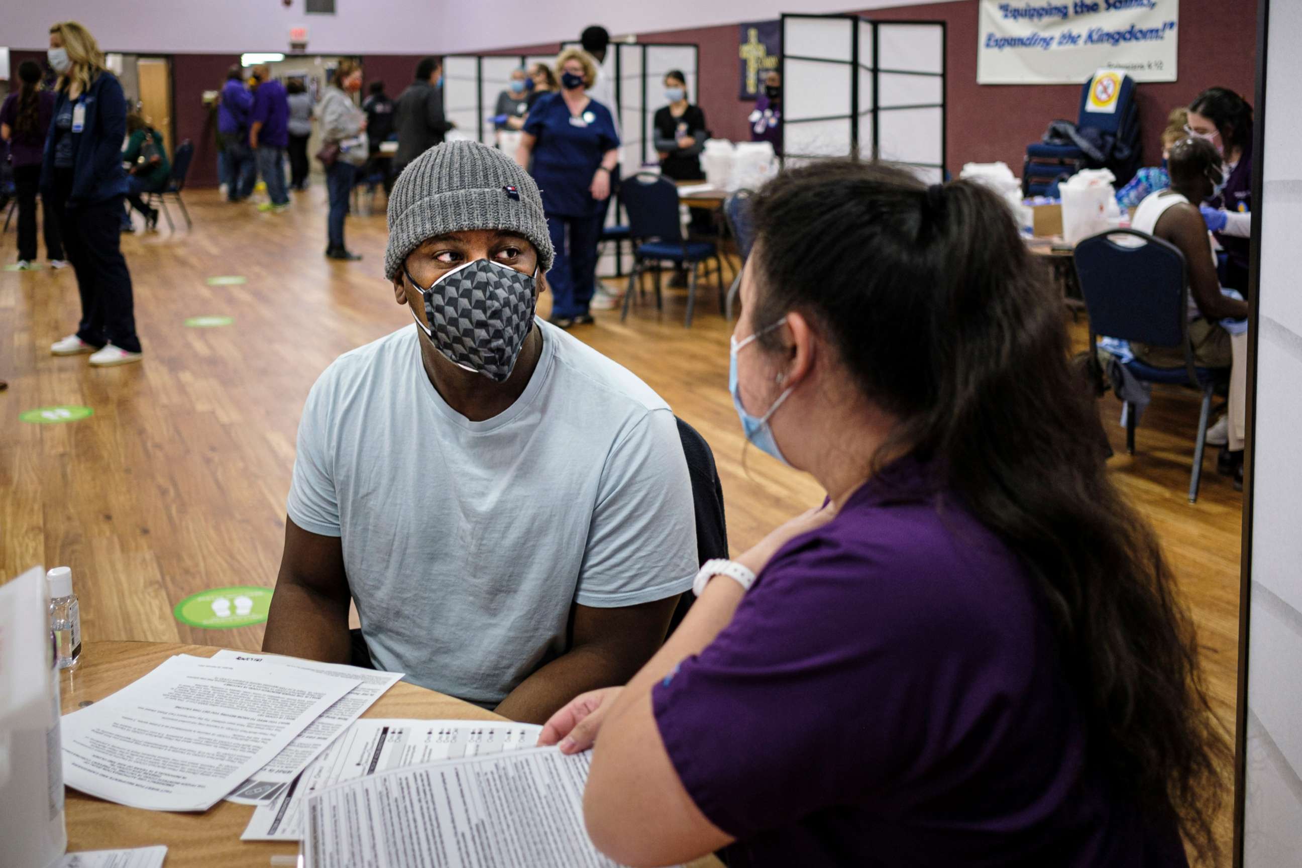 PHOTO: Justin Pinkney talks to a nursing student about the COVID-19 vaccination he is about to get during a COVID-19 vaccination clinic at Corinthian Baptist Church in Des Moines, Iowa, March 27, 2021.