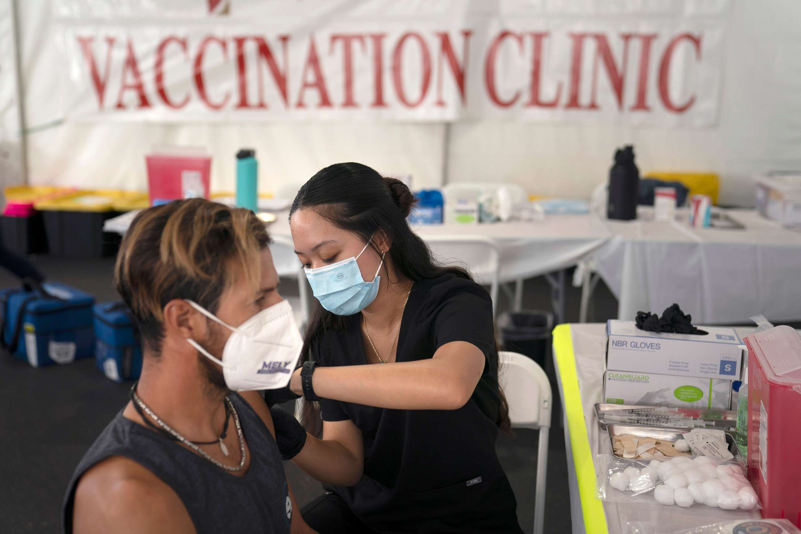 PHOTO: Registered nurse, Noleen Nobleza inoculates Julio Quinones with the COVID-19 vaccine at a clinic set up in a parking lot, Aug. 28, 2021, in Orange, Calif.