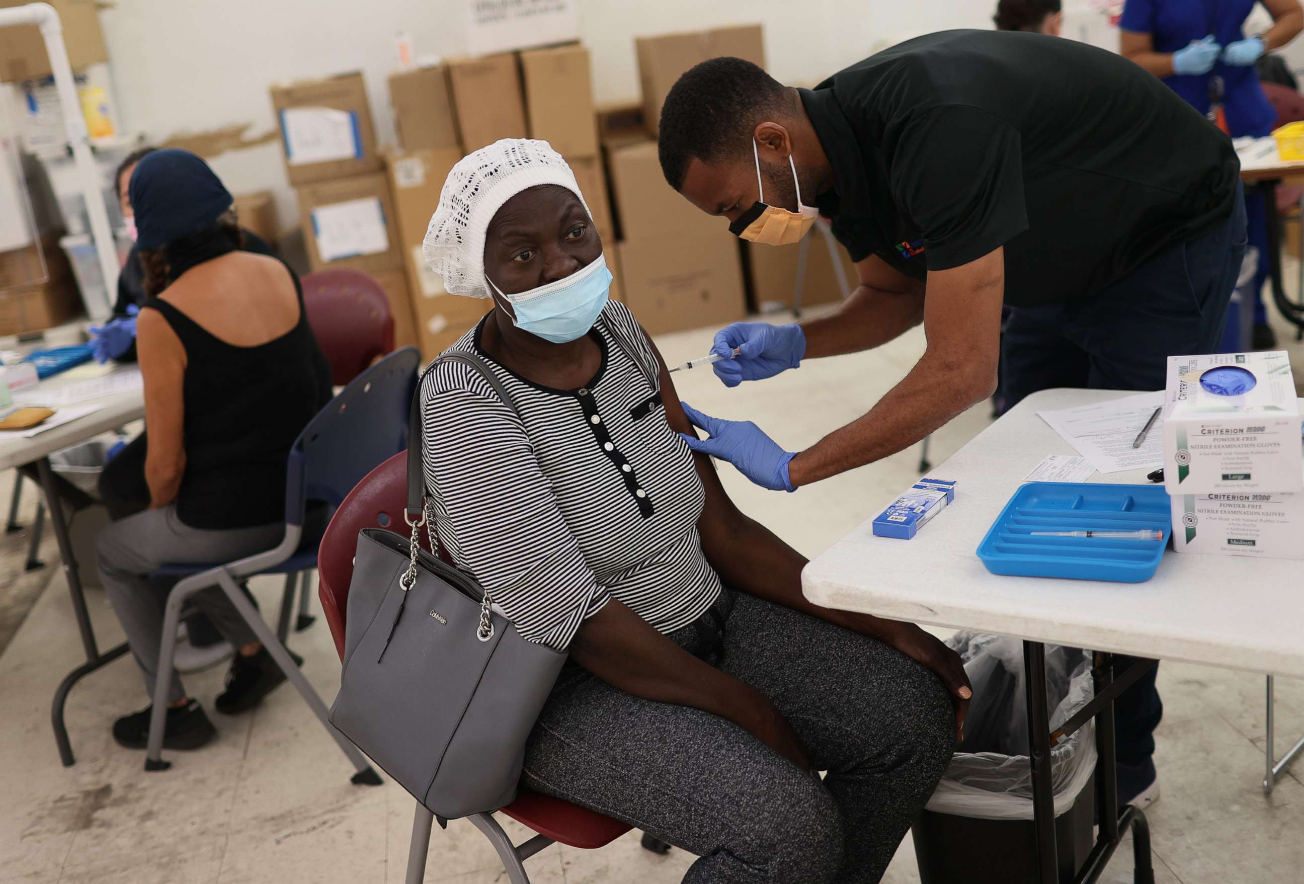 PHOTO: Odilest Guerrier, Medical Assistant, administers a Moderna COVID-19 vaccine to Marie Val at a clinic set up by Healthcare Network, May 20, 2021, in Immokalee, Fla.