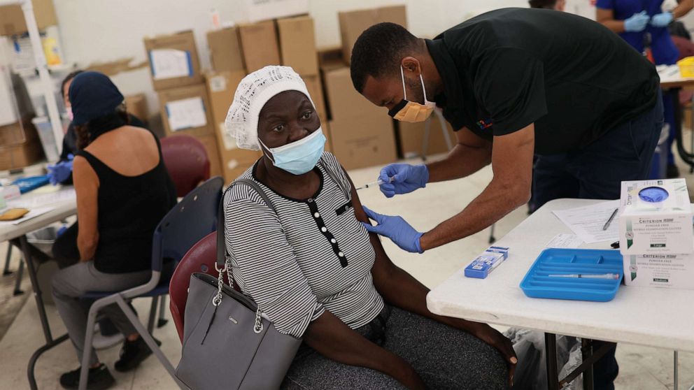 PHOTO: Odilest Guerrier, Medical Assistant, administers a Moderna COVID-19 vaccine to Marie Val at a clinic set up by Healthcare Network, May 20, 2021, in Immokalee, Fla.