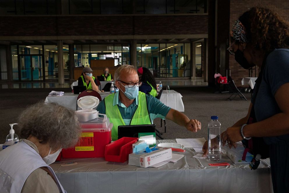 PHOTO: A patient shows her vaccination card to receive her booster dose of the Pfizer-BioNTech coronavirus (COVID-19) vaccine during an Oakland County Health Department vaccination clinic at the Southfield Pavilion, Aug. 24, 2021, in Southfield, Mich.