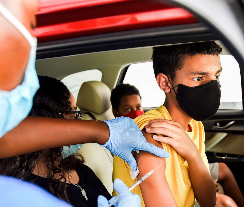 PHOTO: A nurse administers a COVID-19 vaccine to a kid at a drive-thru COVID-19 testing and vaccination site at Barnett Park in Orlando.