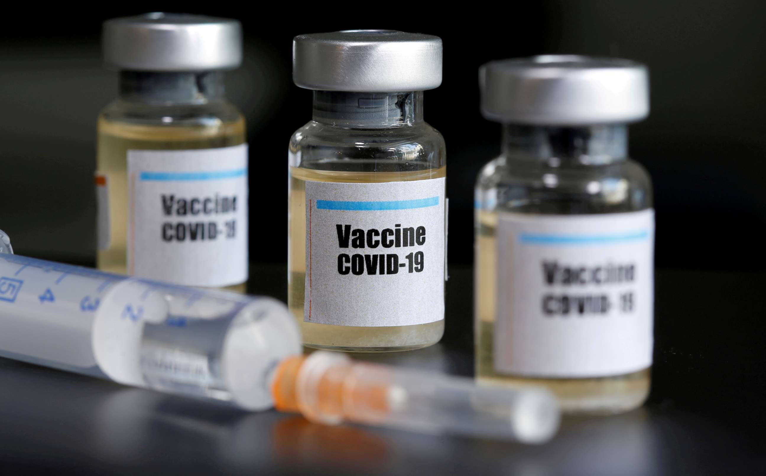 PHOTO: Small bottles labeled with a "Vaccine COVID-19" sticker alongside a medical syringe are seen in this illustration taken on April 10, 2020.