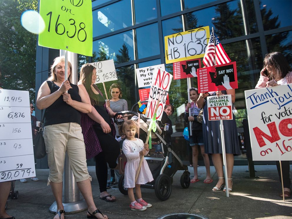 religion PHOTO: A group of anti-vaccine protesters gather in front of Vancouver City Hall prior to the signing of HB 1638 in Vancouver Wash., on May 10, 2019.