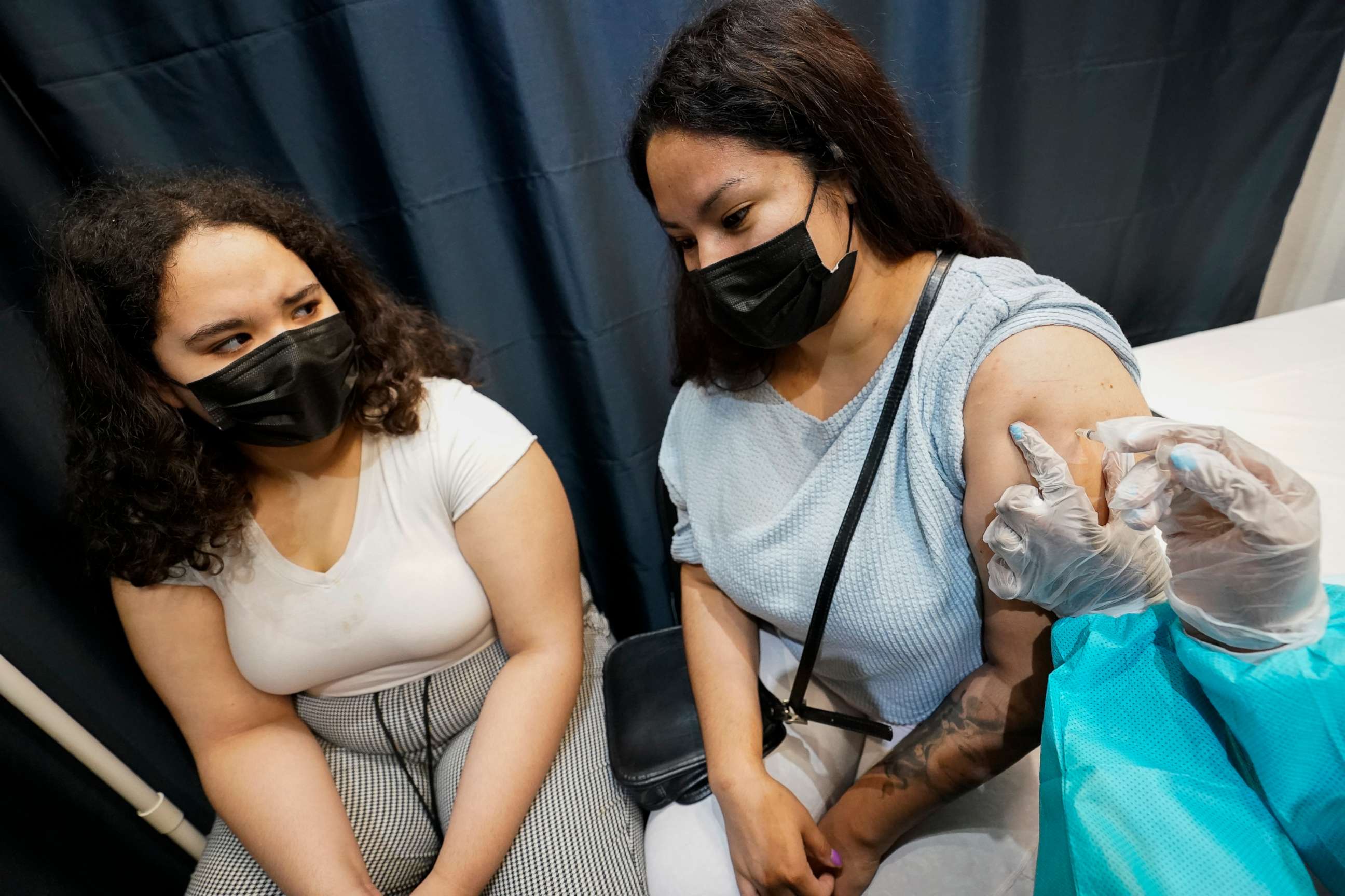 PHOTO: A health care worker inoculates Evelyn Pereira, right, of Brooklyn, with the first dose of the Pfizer COVID-19 vaccine as her daughter Soile Reyes, 12, looks on, July 22, 2021, at the American Museum of Natural History in New York.