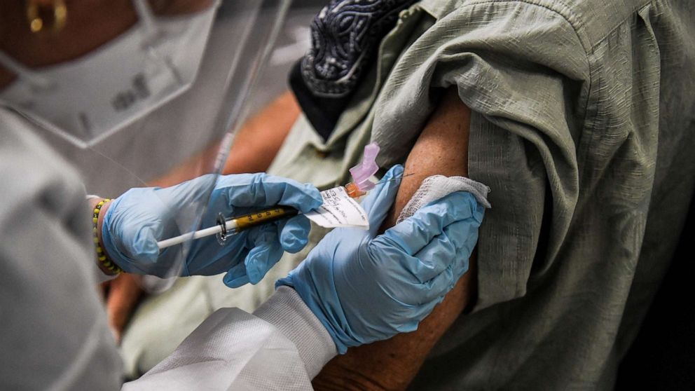 PHOTO: A man receives a COVID-19 vaccination from Yaquelin De La Cruz at the Research Centers of America (RCA) in Hollywood, Fla., Aug. 13, 2020. 