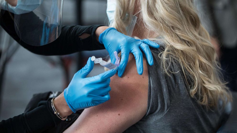 PHOTO: A woman receives the COVID-19 vaccine at Gillette Stadium on Jan. 15, 2021, in Foxborough, Mass.