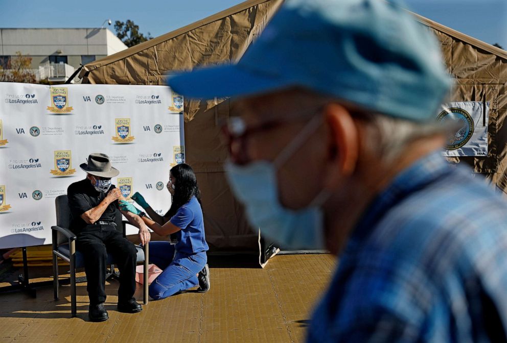 PHOTO: Morris Chester left, receives the COVID-19 vaccination by nurse Stacey Torio as fellow World War II Veteran Bernard Waldow, right, waits for his turn at the VA Greater Los Angeles on Jan. 8, 2021.