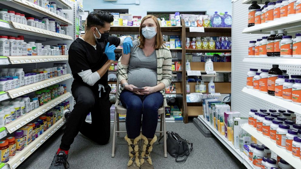 PHOTO: Michelle Melton, who is 35 weeks pregnant, receives the Pfizer-BioNTech vaccine against the coronavirus disease (COVID-19) at Skippack Pharmacy in Schwenksville, Pennsylvania, Feb. 11, 2021.