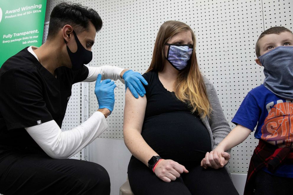 PHOTO: In this Feb. 11, 2021, file photo, Aubrie Cusumano, who is 39 weeks pregnant, receives the Pfizer-BioNTech vaccine while holding her son, Luca's hand at Skippack Pharmacy in Schwenksville, Penn.