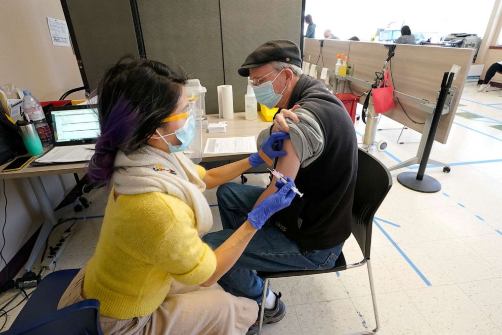 PHOTO: Substitute teacher Oscar Gardner, 76, right, gets the first dose of the Moderna COVID-19 vaccine from Kim Vo, left, a pharmacist working for the Seattle Indian Health Board, March 15, 2021, at a SIHB clinic in Seattle.
