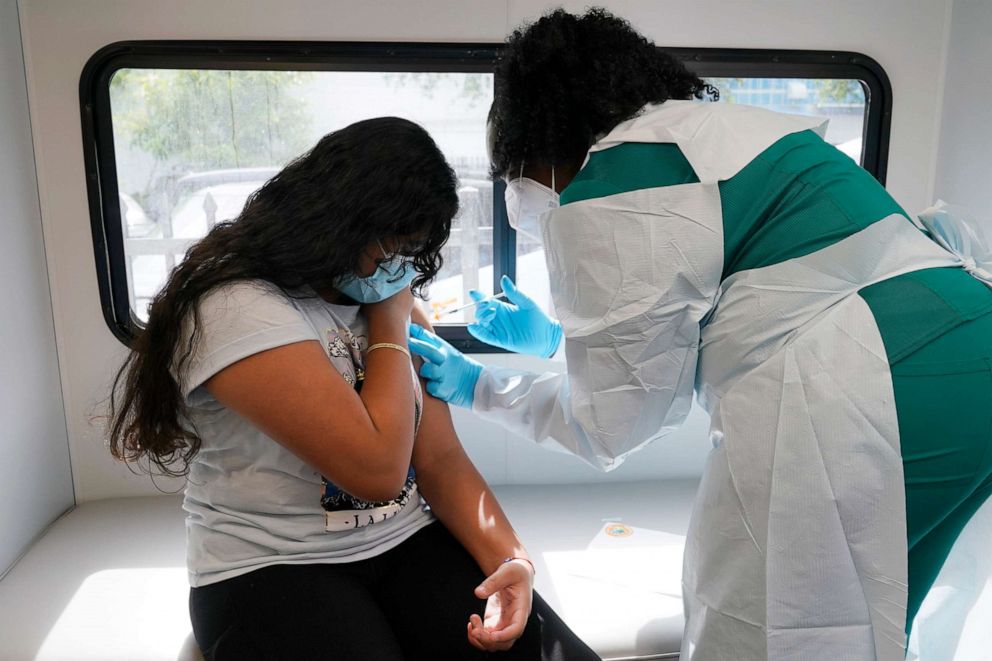 PHOTO: Jenna Ramkhelawan, 12, receives the first dose of the Pfizer Covid-19 vaccine from LPN nurse Dolores Fye, May 18, 2021, in Miami.