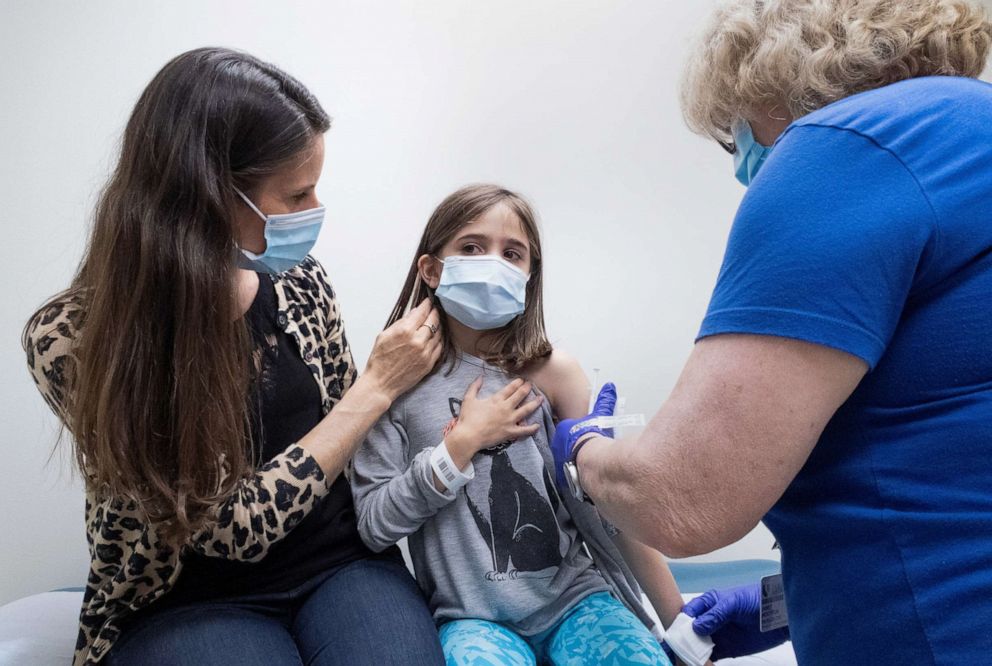 PHOTO: Marisol Gerardo, 9, sits at alongside her mother as she gets the second dose of the Pfizer COVID-19 vaccine during a clinical trial for children at Duke Health in Durham, N.C., April 12, 2021.