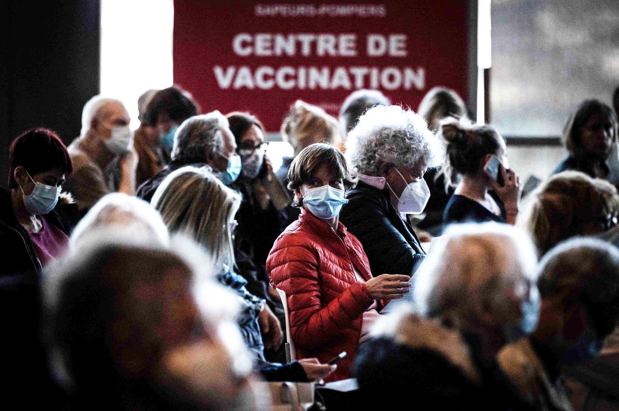 PHOTO: People sit in a waiting area before being vaccinated against COVID-19 on the opening day of a mass vaccination center set up in the OL Group's Groupama Stadium, in Decines-Charpieu, on April 3, 2021.