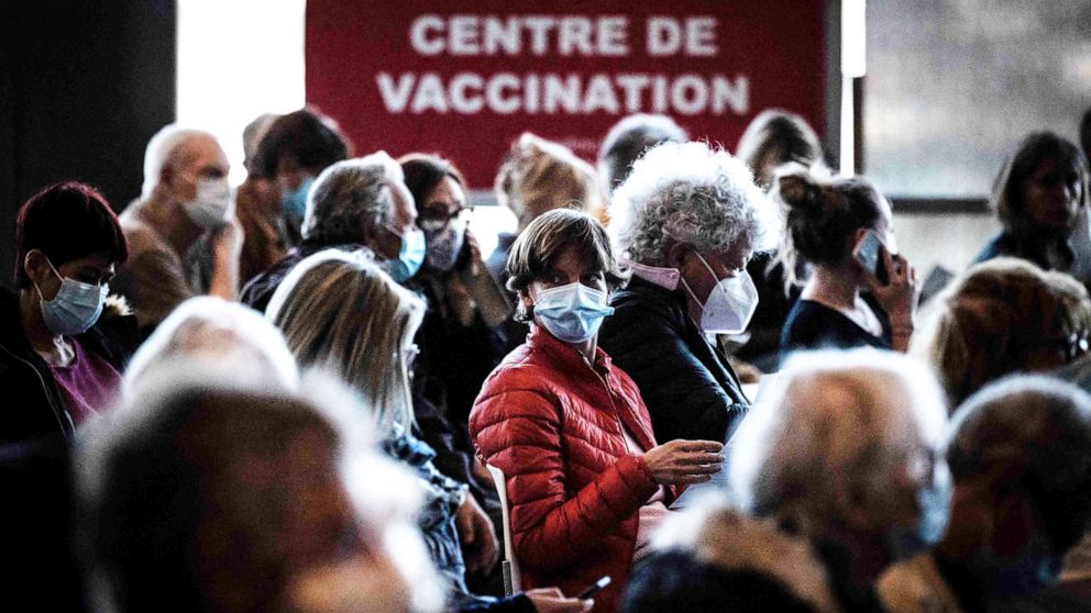 PHOTO: People sit in a waiting area before being vaccinated against COVID-19 on the opening day of a mass vaccination center set up in the OL Group's Groupama Stadium, in Decines-Charpieu, on April 3, 2021.