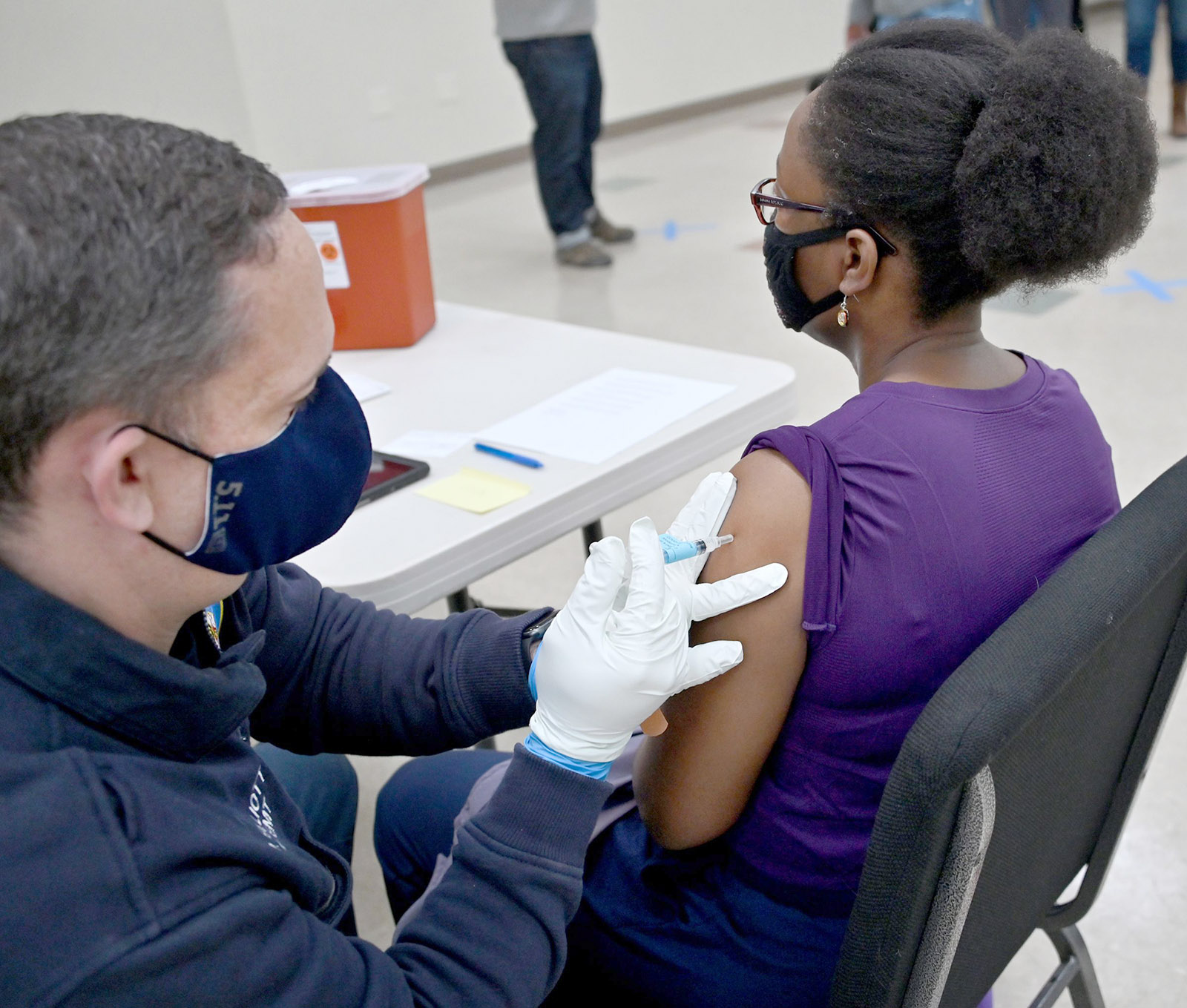 PHOTO: A Howard County Firefighter and EMT gives a COVID-19 vaccination to a woman at St. John Baptist Church in Columbia, Md., March 17, 2022. 