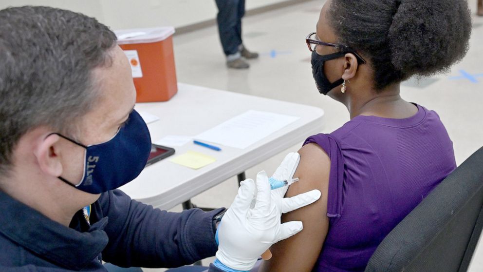 PHOTO: A Howard County Firefighter and EMT gives a COVID-19 vaccination to a woman at St. John Baptist Church in Columbia, Md., March 17, 2022. 