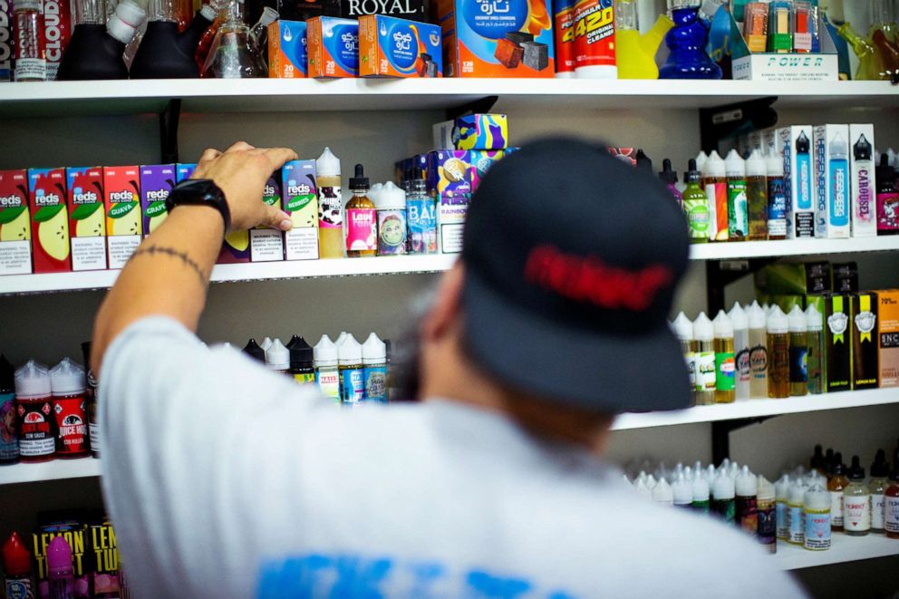 PHOTO: A vape shop worker organizes electronic smoking products in a local store in Jersey City, N.J.,  Sept. 12, 2019. 