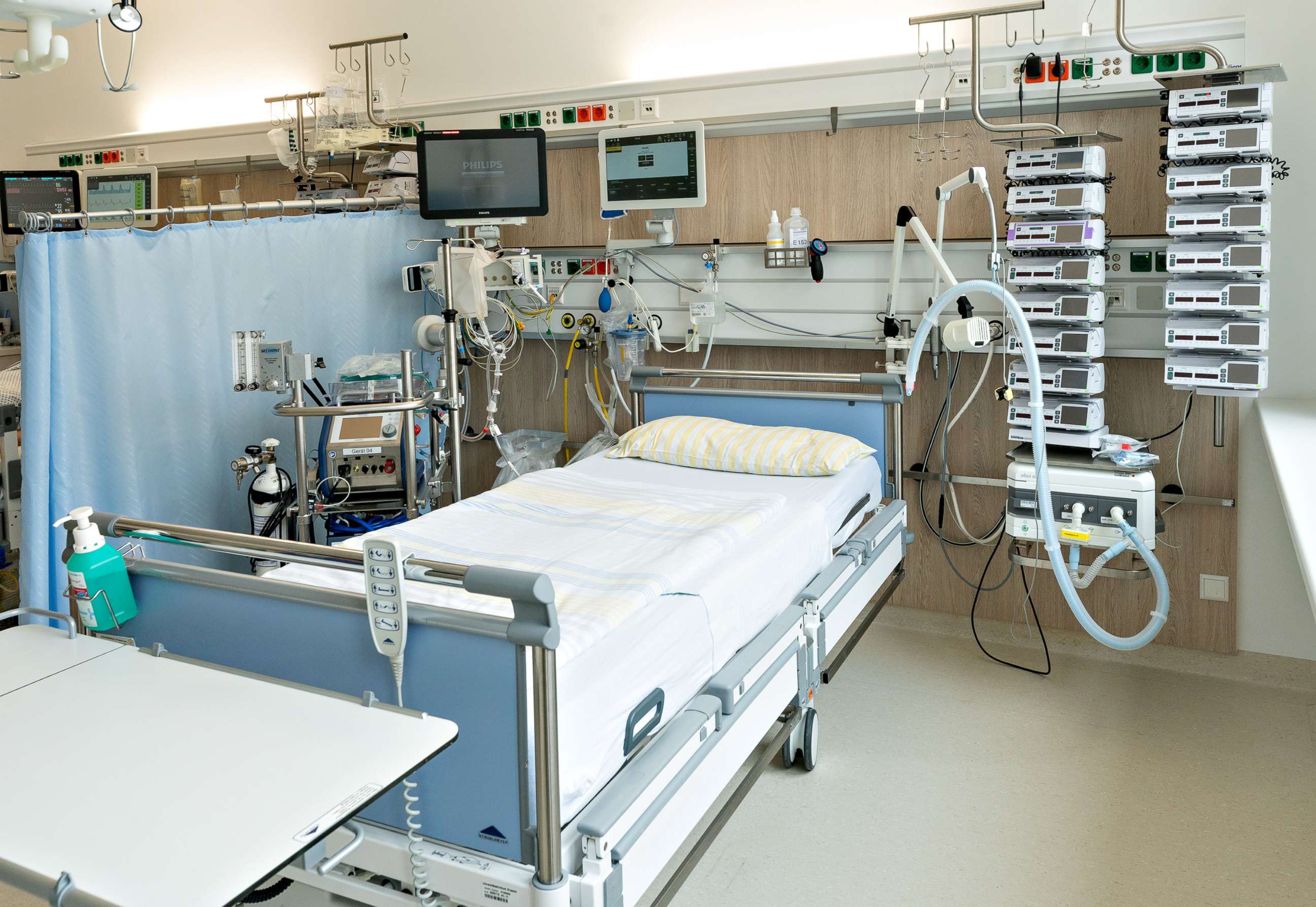 PHOTO: An bed in an intensive care unit of the University Hospital Dresden. On the left side of the bed is a heart-lung machine, on top are the monitors for monitoring vital functions. To the right of the bed is a ventilator and infusion equipment. 