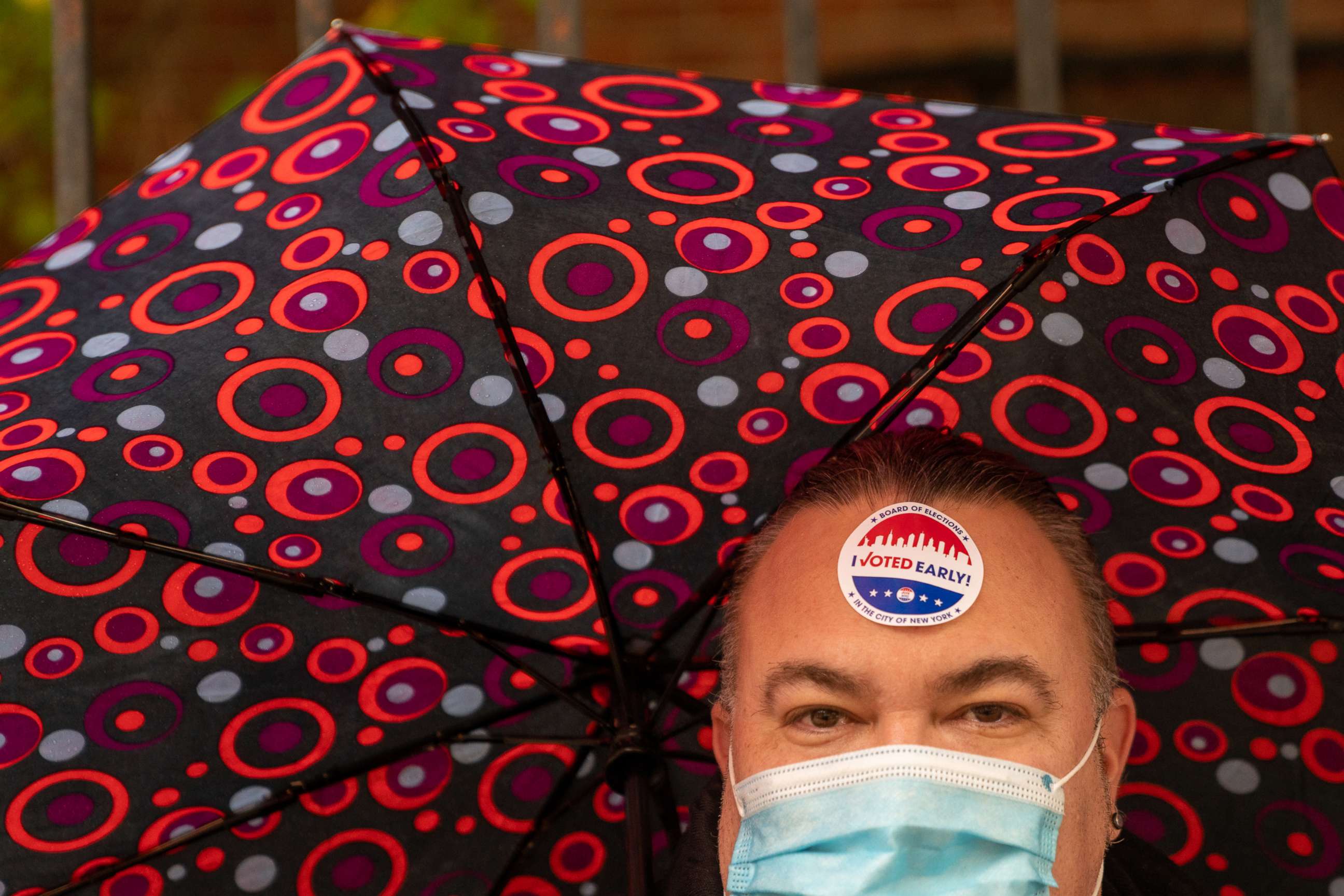 PHOTO: A person carries an umbrella and wears a mask at a polling station in Hunter-Bellevue School of Nursing on Nov. 1, 2020, in New York.