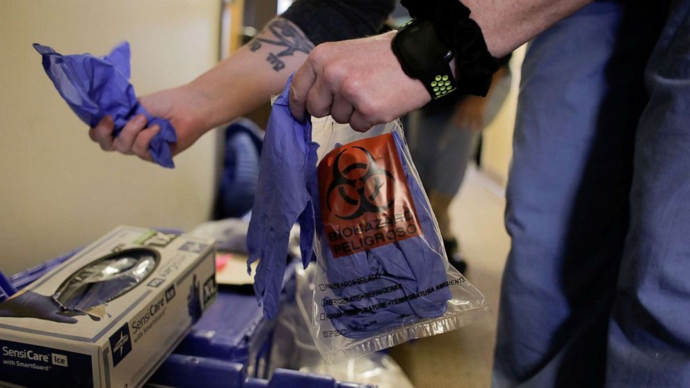 PHOTO: An epidemiologist holds gloves while arranging the supplies of Harborview Medical Center's home assessment team, during preparations to visit a person potentially exposed to coronavirus at Harborview Medical Center in Seattle on Feb. 29, 2020.