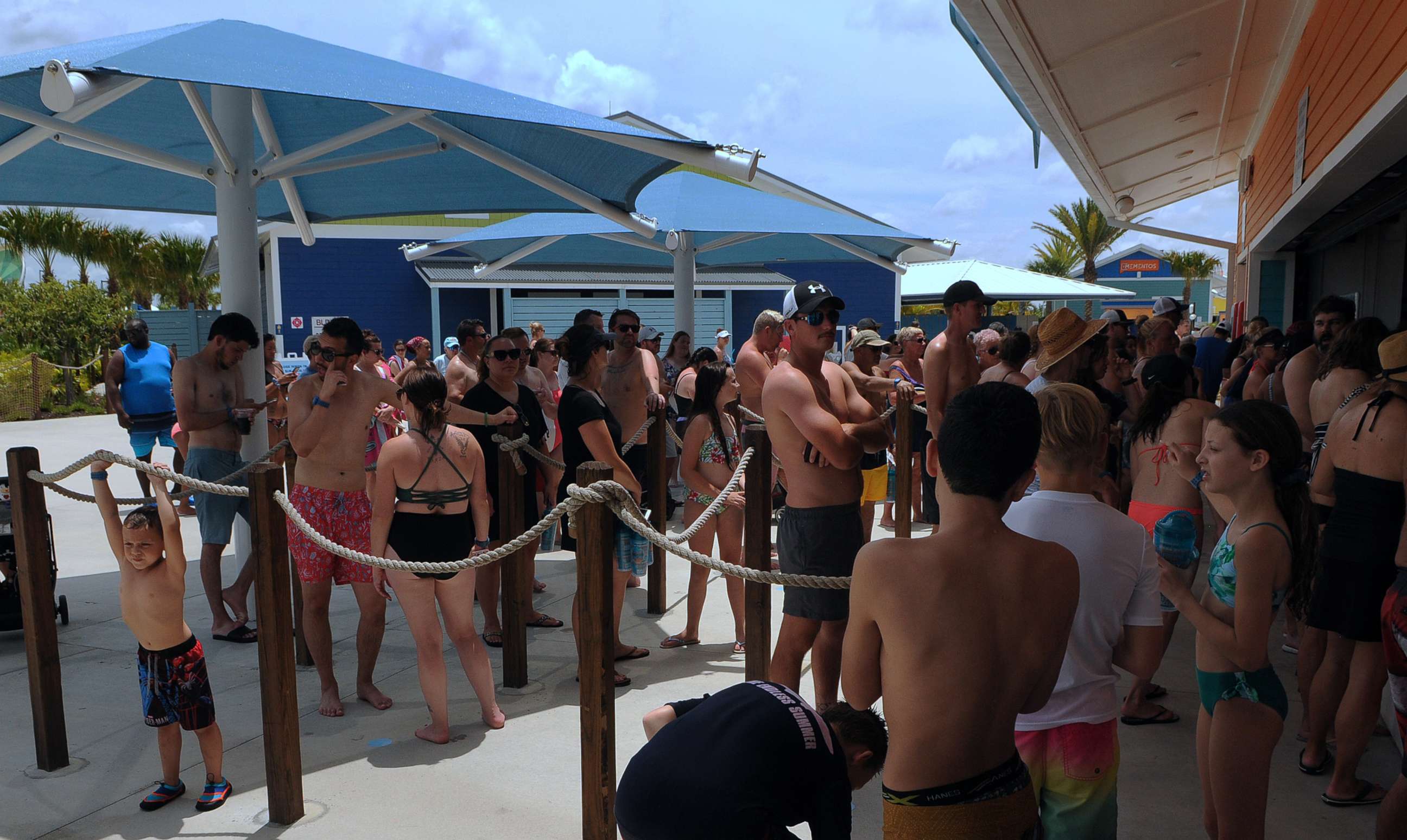 PHOTO: People wait in a queue at a snack bar at Island H2O Live! water park as the attraction becomes the only major water park in the Orlando area to reopen for Memorial Day weekend after closing for the coronavirus pandemic.