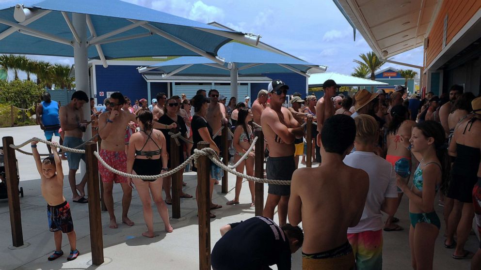 PHOTO: People wait in a queue at a snack bar at Island H2O Live! water park as the attraction becomes the only major water park in the Orlando area to reopen for Memorial Day weekend after closing for the coronavirus pandemic.