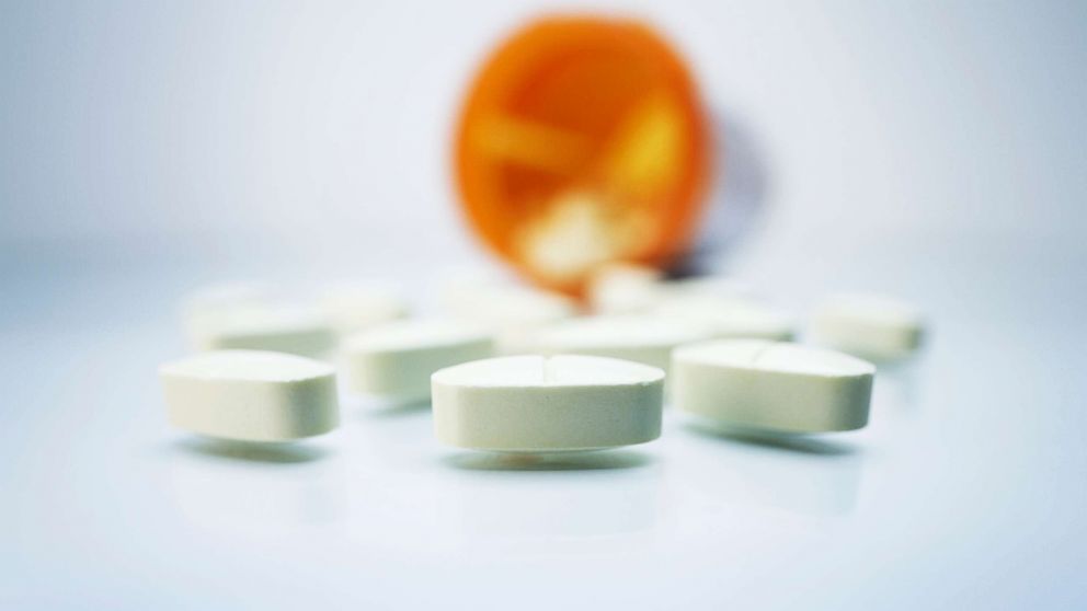 White pills and a plastic prescription pill container.