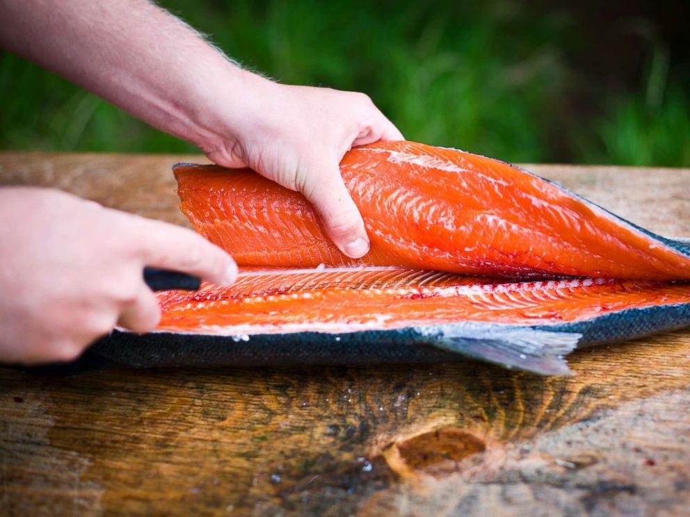 PHOTO: A person fillets a freshly caught wild salmon in an undated stock photo.
