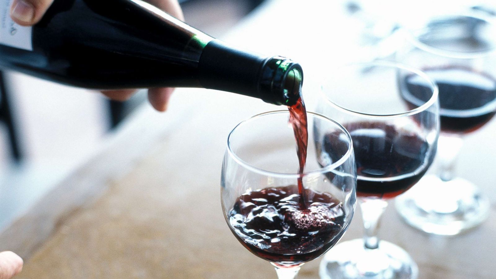 PHOTO: A person is pictured pouring red wine.