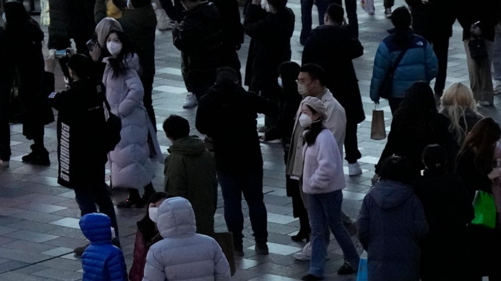 Passengers arriving from China wait in front of a COVID-19 testing area set at the Roissy Charles de Gaulle airport, north of Paris, Sunday, Jan. 1, 2023. France says it will require negative COVID-19 tests of all passengers arriving from China and i