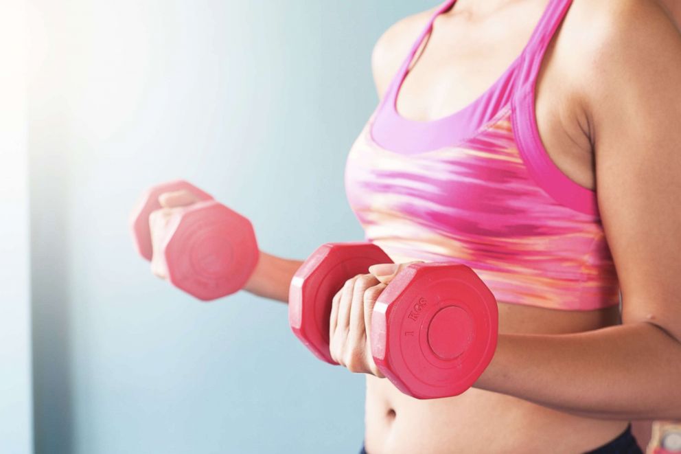 PHOTO: In this undated stock photo, a woman exercises using red dumbbells.