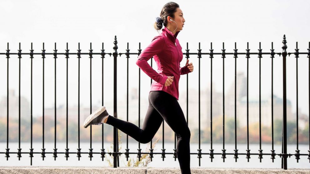 Running female bare feet in long leggings. Mature woman runs Stock