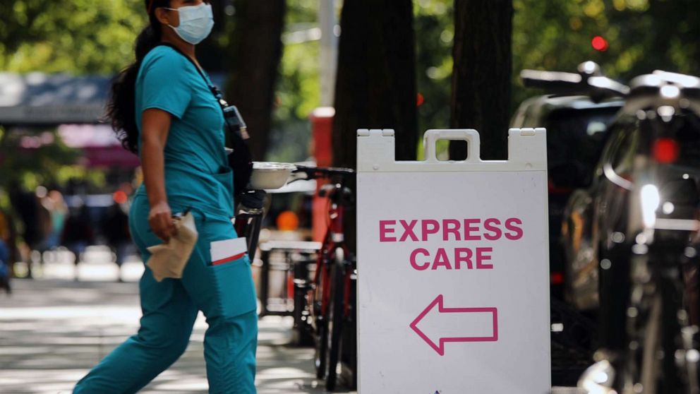 PHOTO: A medical worker walks past a sign that reads "Express Care."