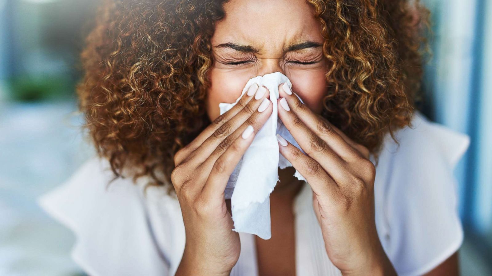 PHOTO: A woman uses a tissue to sneeze in this undated stock photo.