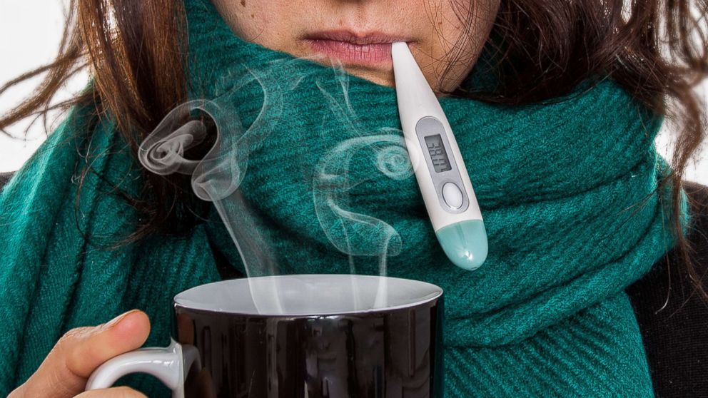 A woman takes her temperature in this undated stock photo.