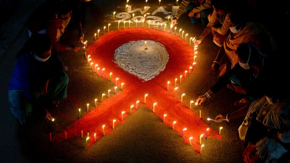 PHOTO: Volunteers and sex workers light candles forming the shape of a red ribbon during an awareness event on the eve of the 'World AIDS Day' in Siliguri, India,  Nov. 30, 2021. 