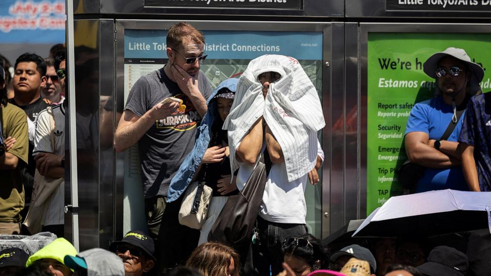 PHOTO: A supporter of Japan wraps himself under his shirt to shield himself from the sun and heat during the 2026 World Cup football tournament between Japan and the Netherlands, at a watch party in Los Angeles, June 14, 2026.