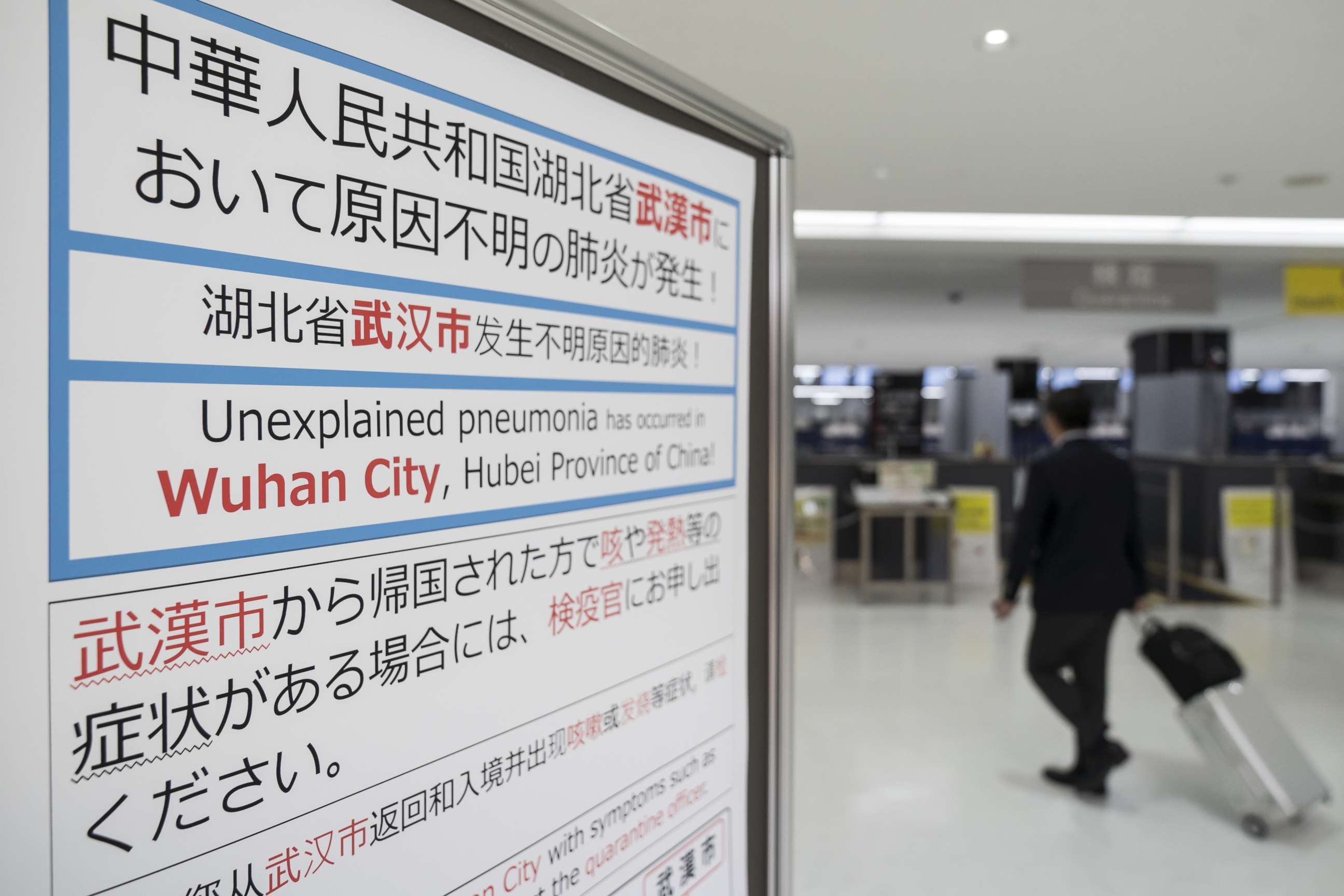 PHOTO: A passenger walks past a notice for  passengers from Wuhan, China displayed near a quarantine station at Narita airport on Jan. 17, 2020, in Narita, Japan.